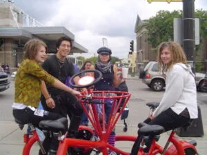 Young people sitting on a conference bike.