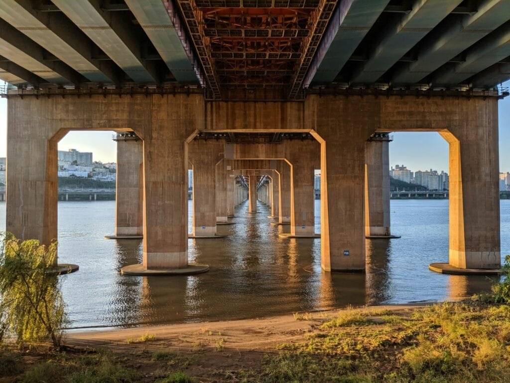 a view of the underside of a bridge over a body of water