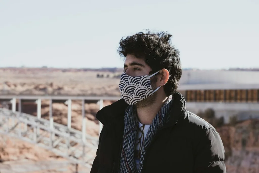 man in black jacket wearing white and black mask