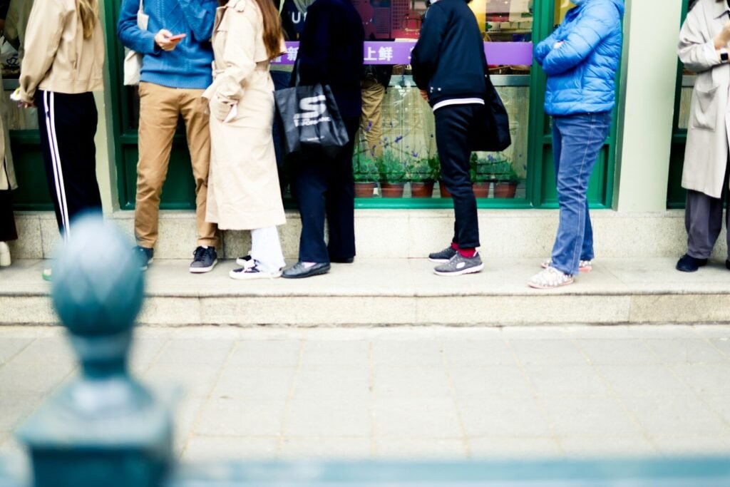 a group of people standing on a sidewalk